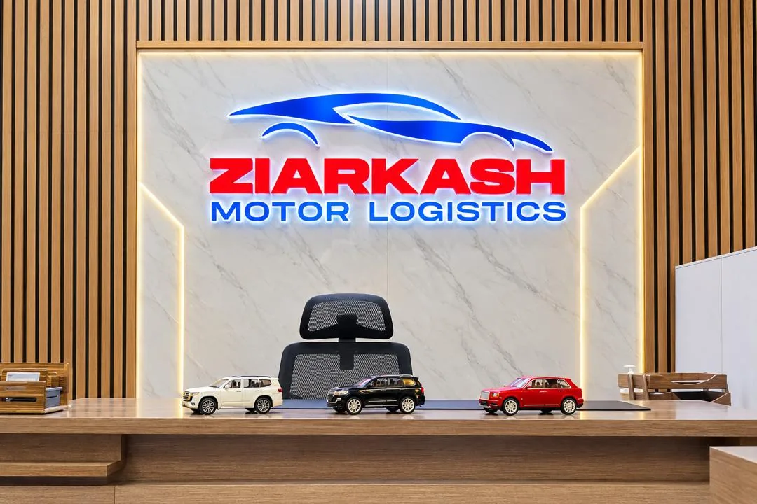 Ziarkash Motor Logistics office reception with branded wall and model cars